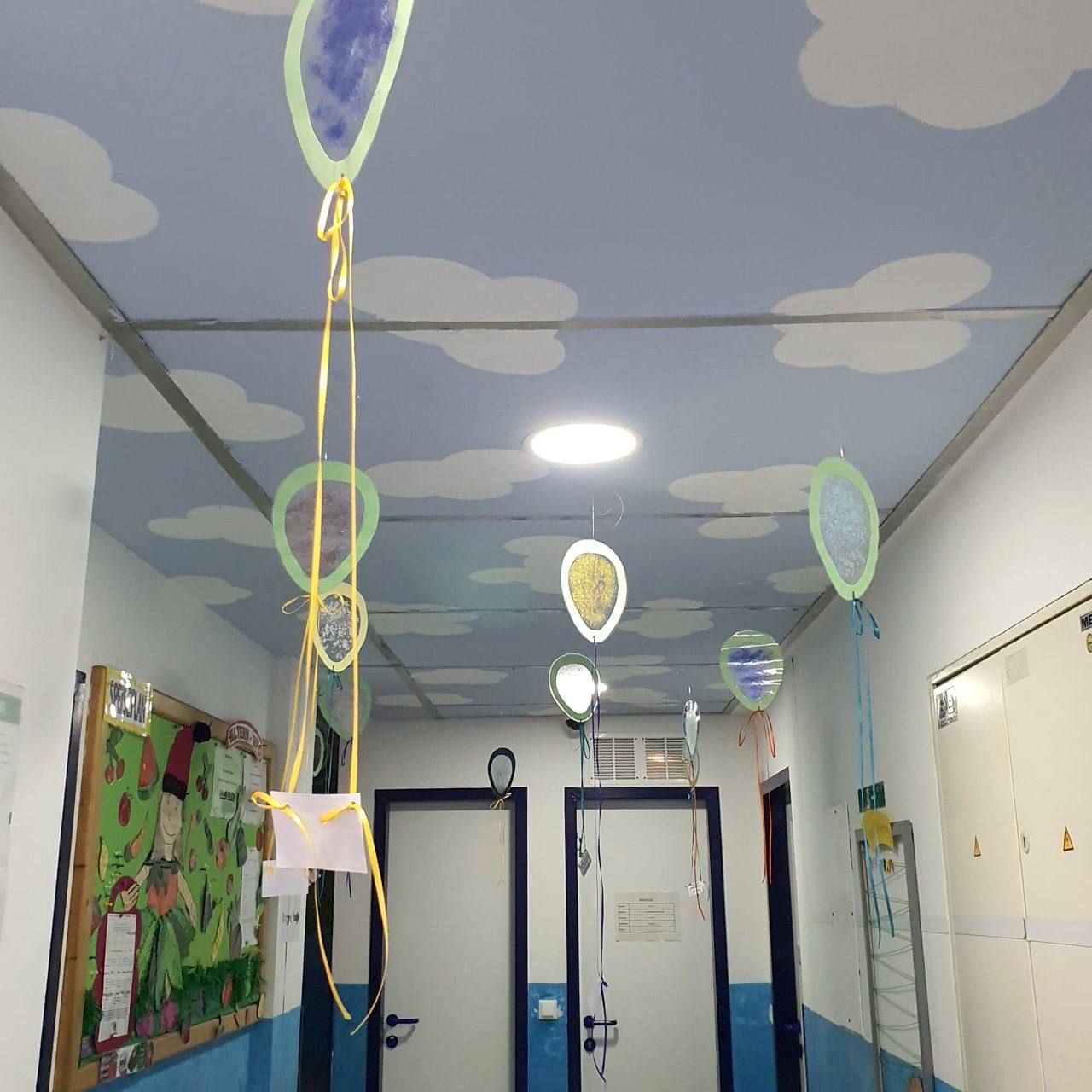 Gang mit Wolkenhimmel und Papierballons an der Decke