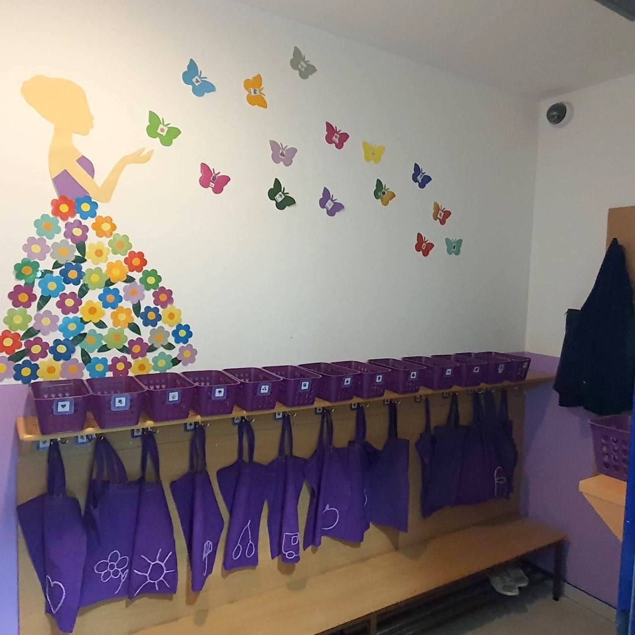 Garderobe mit Schmetterlingswand und lila Taschen