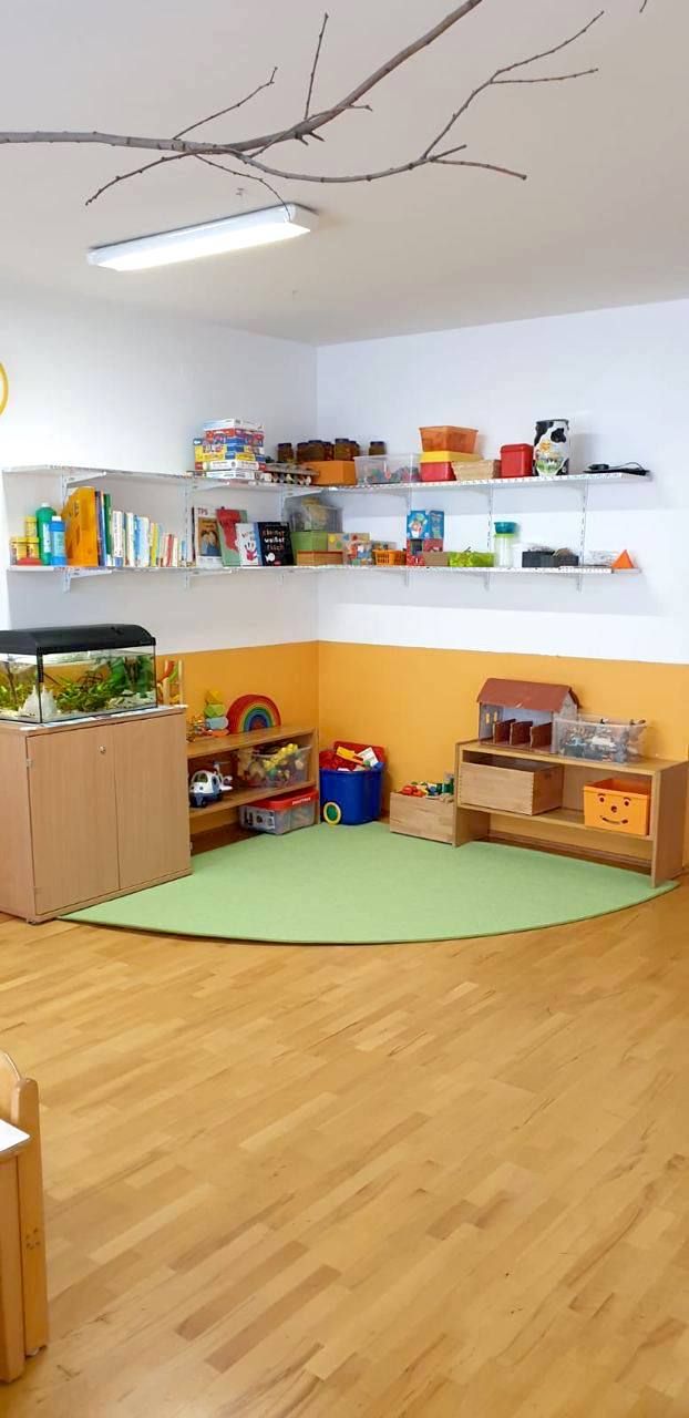 Gruppenraum mit Bücherregal, Spielzeug und Aquarium