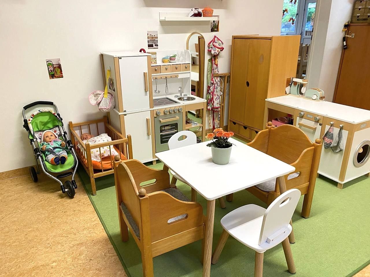 Spielecke mit Puppenküche, Puppenwagen und Tisch