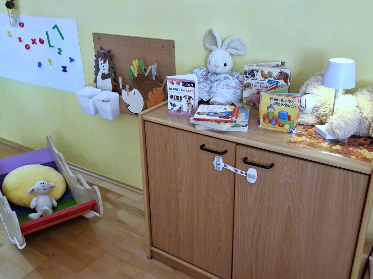 Puppenecke mit Puppenwiege, Büchern und Stofftieren